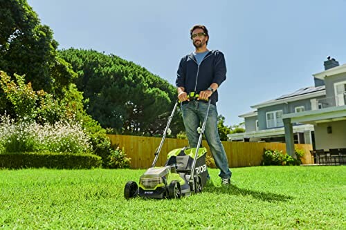 Homme tondant la pelouse avec une tondeuse à gazon.