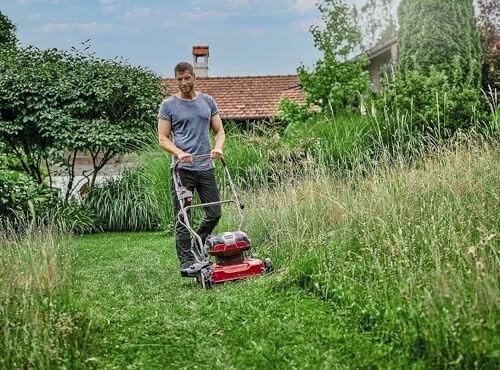 Homme tondant la pelouse avec une tondeuse à gazon