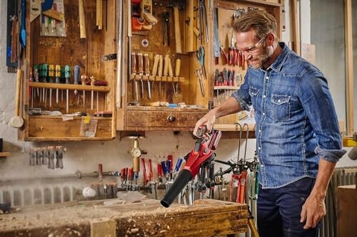 Homme utilisant un outil électrique dans un atelier de menuiserie.