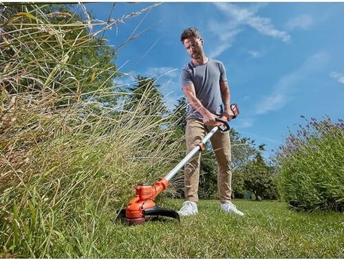 Homme utilisant un coupe-bordure dans le jardin.