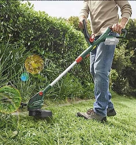 Homme utilisant un coupe-bordures sur la pelouse.