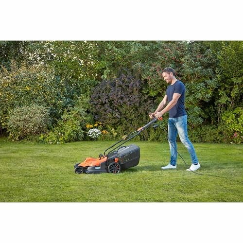 Homme tondant la pelouse dans un jardin.