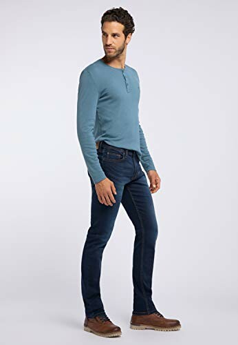 Homme portant un pull bleu et un jean.