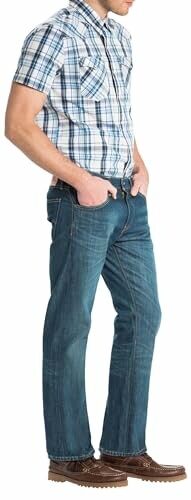 Homme portant une chemise à carreaux et un jean.