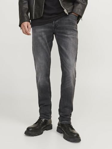 Homme portant un jean foncé et une veste en cuir.