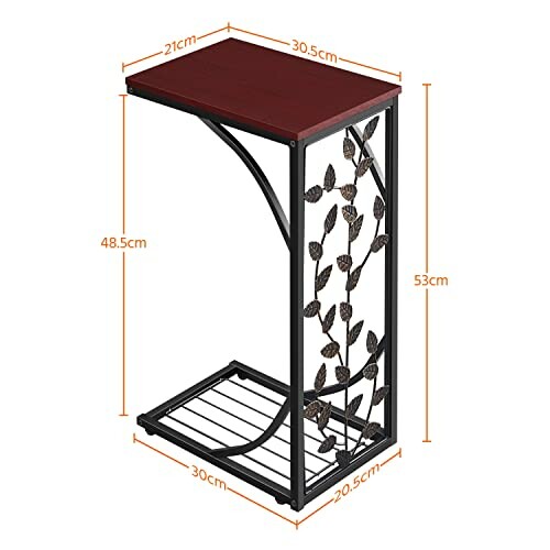 Table d'appoint avec cadre en métal et plateau en bois, ornée de motifs de feuilles.