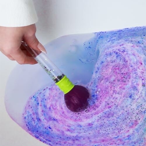 Mélange de peinture violette et bleue dans l'eau avec un pinceau.