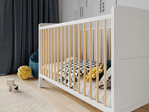 Lit de bébé moderne avec jouets et coussins