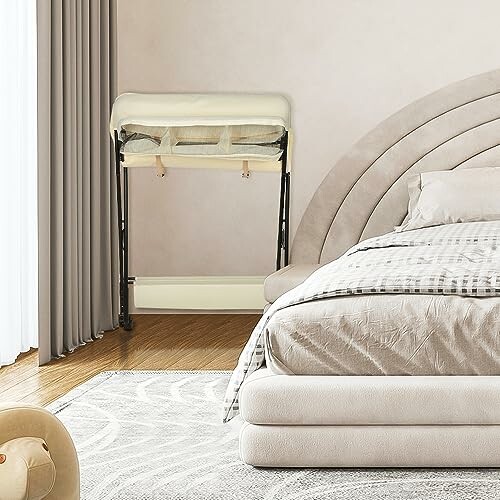 Chambre moderne avec berceau pliant à côté du lit.