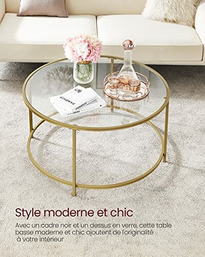 Table basse moderne et chic en verre avec cadre doré, posée sur un tapis clair devant un canapé beige.