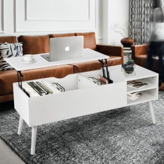 Table basse blanche moderne avec rangement et ordinateur portable.