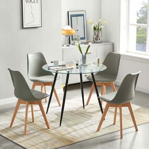 Salle à manger moderne avec table en verre et chaises grises.