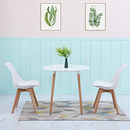 Table à manger moderne avec deux chaises et décoration de plantes.