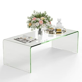 Table basse en verre avec fleurs et plateau décoratif.