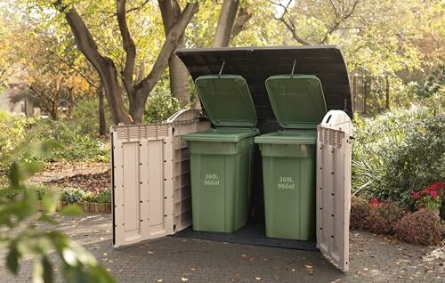 Deux poubelles vertes dans un abri extérieur.