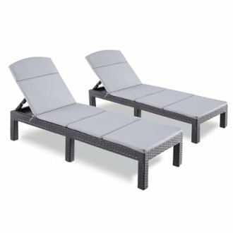 Deux chaises longues d'extérieur grises en rotin.