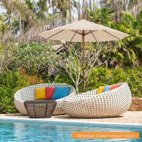 Chaises longues en osier avec coussins autour d'une piscine.