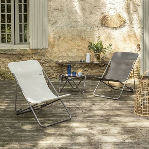 Chaises longues sur une terrasse en bois avec table basse.