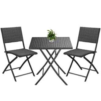 Ensemble de table et chaises de patio en rotin avec plante.