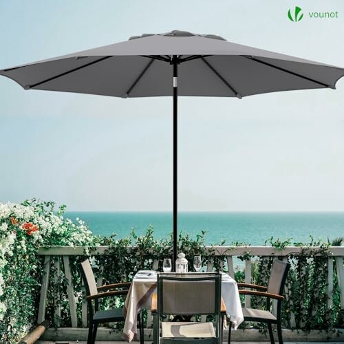 Parasol gris sur une terrasse avec vue sur la mer.