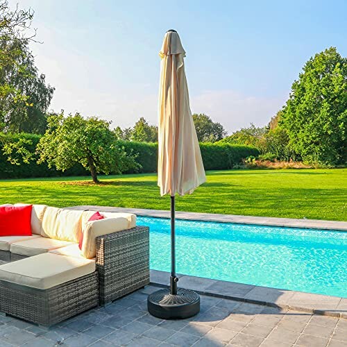 Parasol fermé à côté d'une piscine dans un jardin.