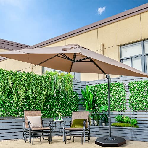 Parasol beige sur une terrasse avec des chaises et des plantes.