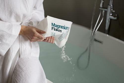 Personne versant des flocons de magnésium dans une baignoire.