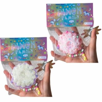 Deux jouets squishy colorés dans des emballages transparents tenus dans des mains.