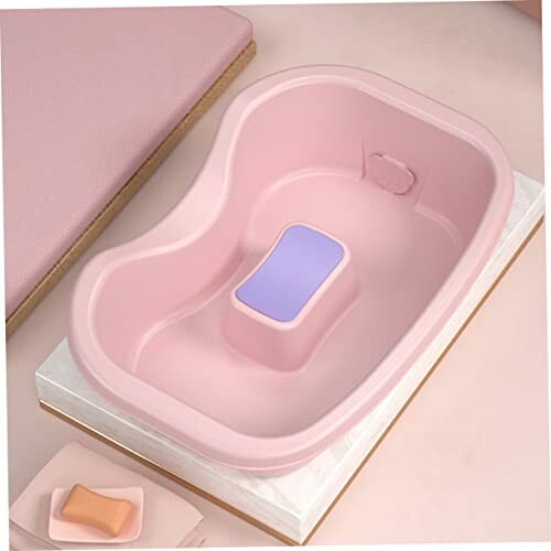 Bassin rose avec savon et coussin violet.