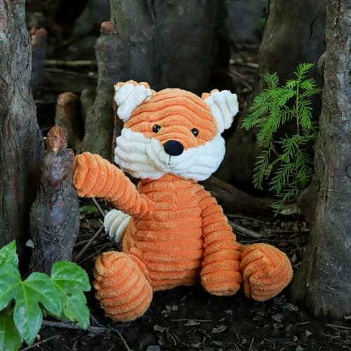 Renard en peluche assis dans la forêt.
