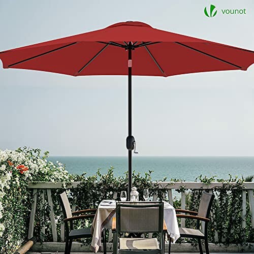 Parasol rouge sur une terrasse au bord de la mer.