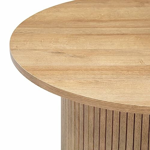 Plateau de table en bois rond avec base à rainures verticales.