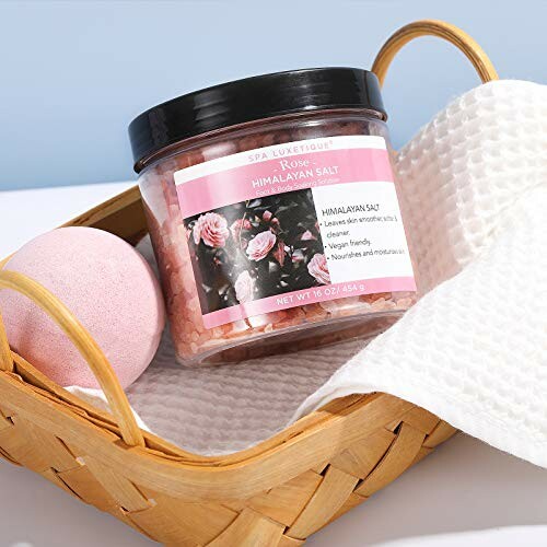 Sel rose de l'Himalaya avec boule de bain et serviette dans un panier.