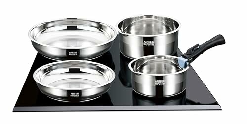 Ensemble de casseroles en acier inoxydable sur une plaque de cuisson noire.