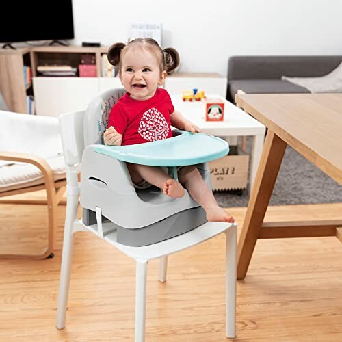 Un enfant souriant assis dans une chaise haute avec un plateau bleu.