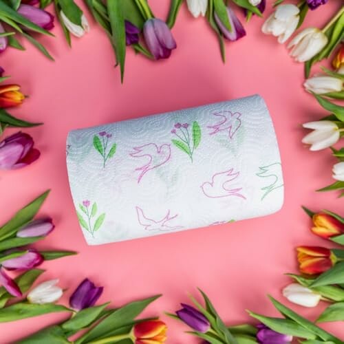 Rouleau de papier toilette entouré de tulipes colorées sur fond rose.