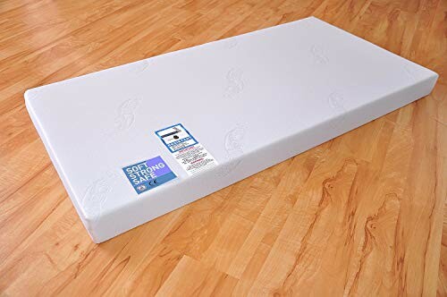 Matelas blanc sur sol en bois