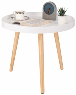 Table basse ronde blanche avec tasse, livre et plante.