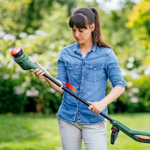 Femme ajustant un coupe-bordures dans le jardin.