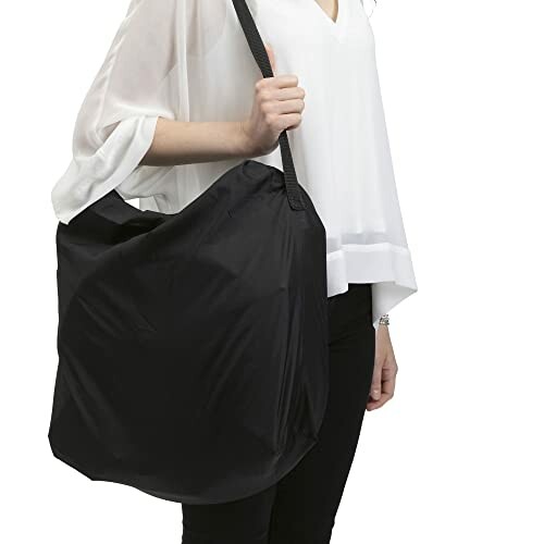 Femme tenant un grand sac fourre-tout noir.