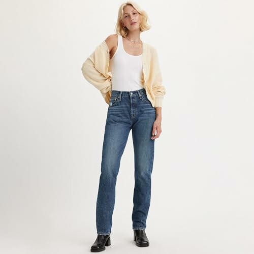 Femme portant un jean et un cardigan beige.