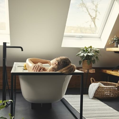 Femme se détendant dans une baignoire sous un toit mansardé.
