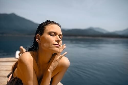 Femme se détendant sur un quai au bord du lac.