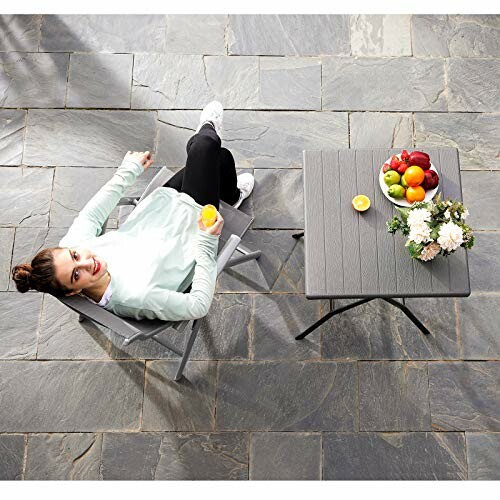 Femme se relaxant sur une terrasse avec une table et des fruits