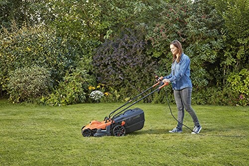 Femme tondant la pelouse avec une tondeuse électrique