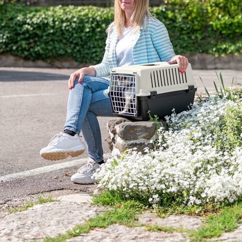 Femme assise avec une caisse de transport pour animaux.