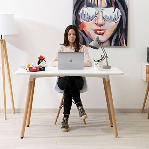 Femme travaillant sur un ordinateur portable à un bureau moderne.