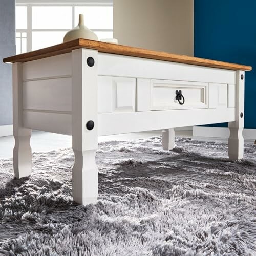 Table basse en bois blanc sur tapis gris.