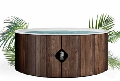 Bain à remous en bois entouré de plantes tropicales.