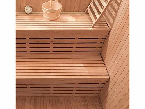 Intérieur en bois d'un sauna avec bancs et seau.
